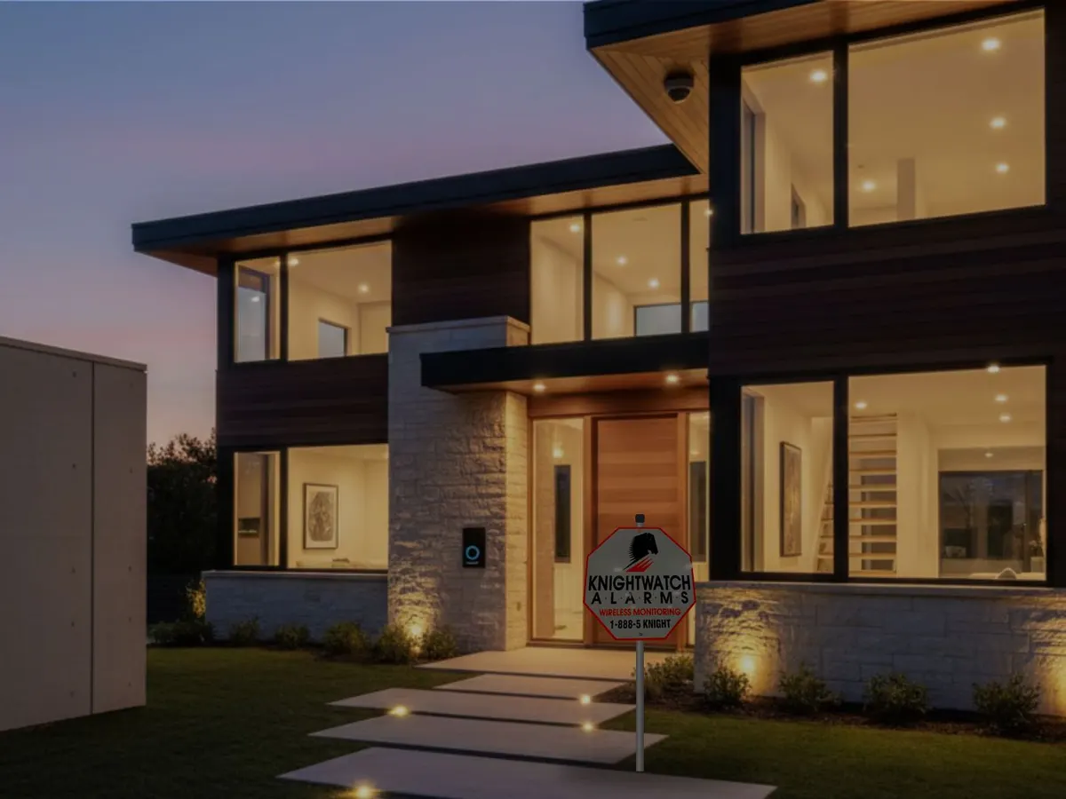 Contemporary home at dusk with a security camera and a Knightwatch lawn sign